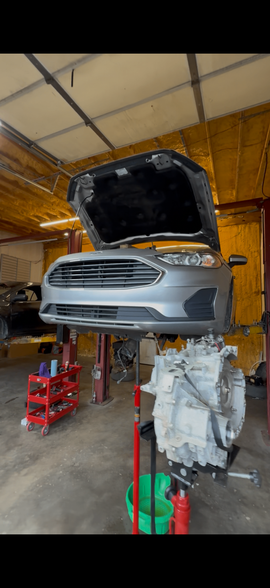 Reparación de transmisión en un Ford Fusion sobre el elevador